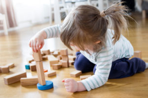 Jong meisje aan het spelen met houten speelgoed